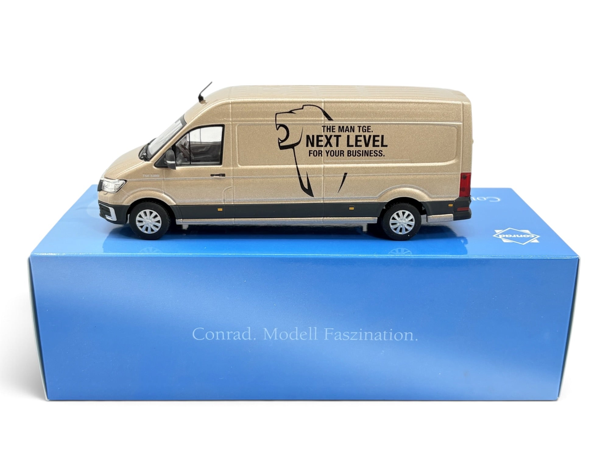 Conrad MAN TGE 3.180 Kastenwagen „Next Level“ Champagner-Metallic – Diecast-Sammlermodell 1:50, Art. 1615/17 – auf Conrad-Verpackung